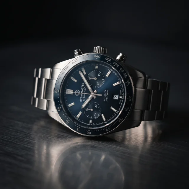 High-detail hero shot of a premium wristwatch on brushed steel, dramatic single-source studio light with a soft rim highlight along the case